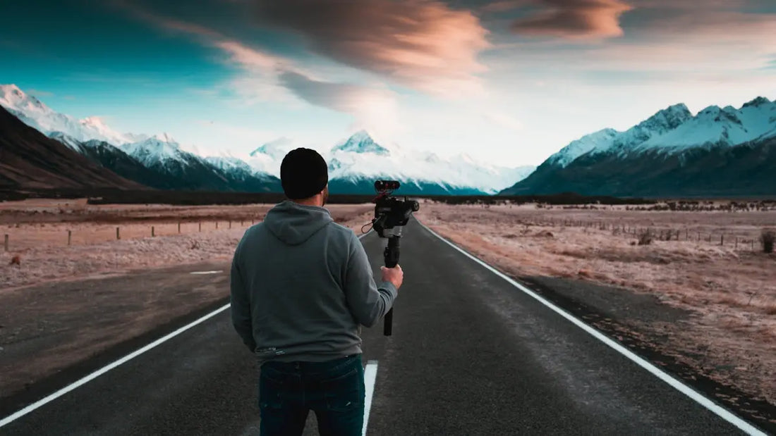 man holding camera standing on empty road