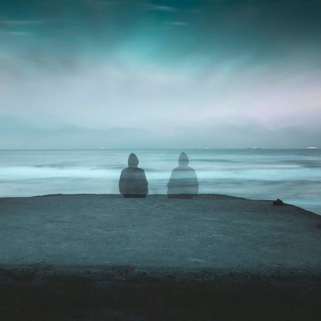 3 white and gray stone on black sand near body of water during daytime