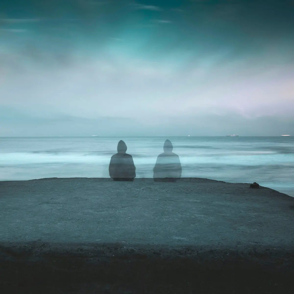 3 white and gray stone on black sand near body of water during daytime