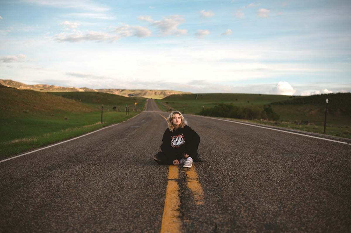 a woman sitting on the side of a road