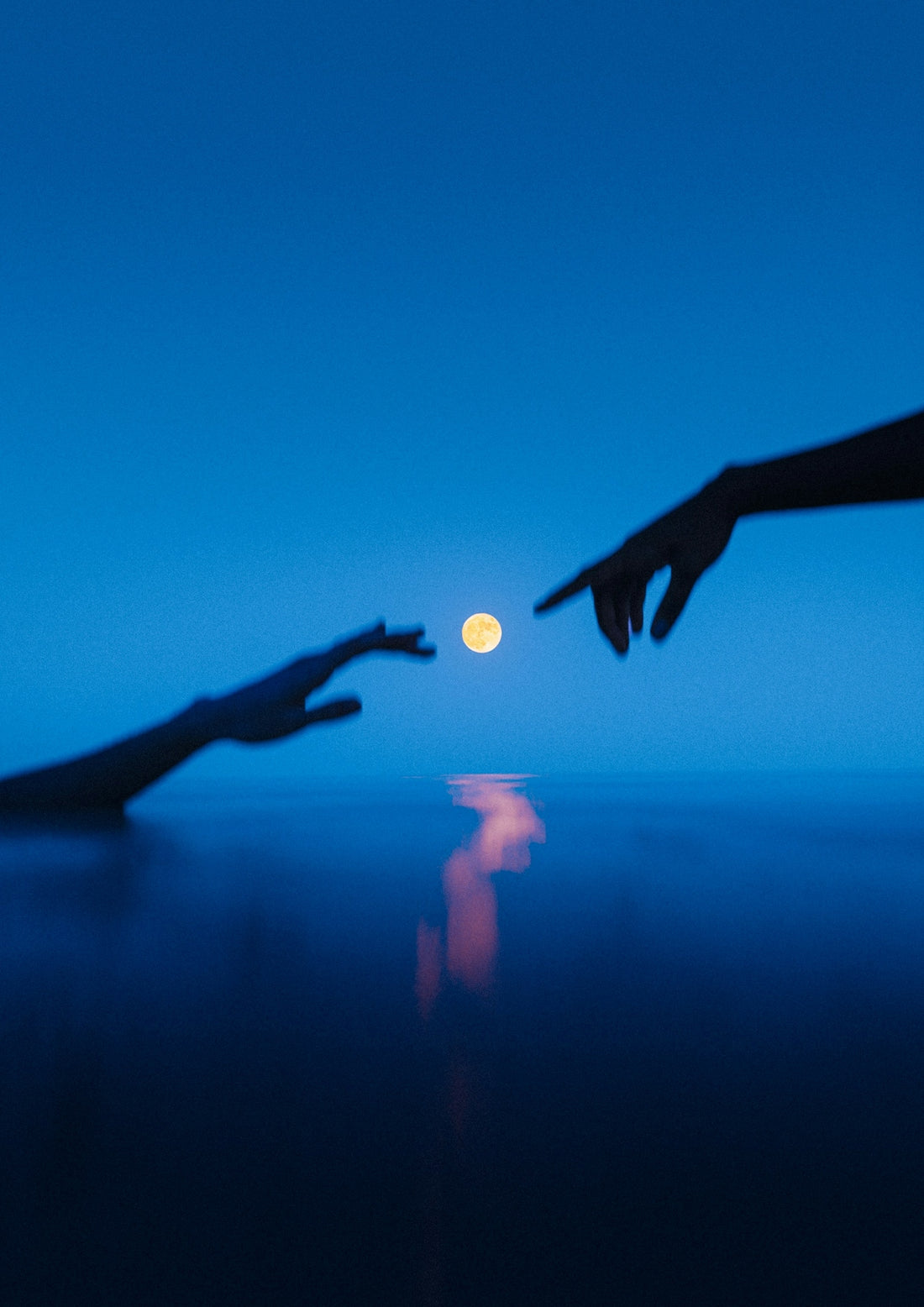 Two hands reaching out towards each other with a full moon in the background