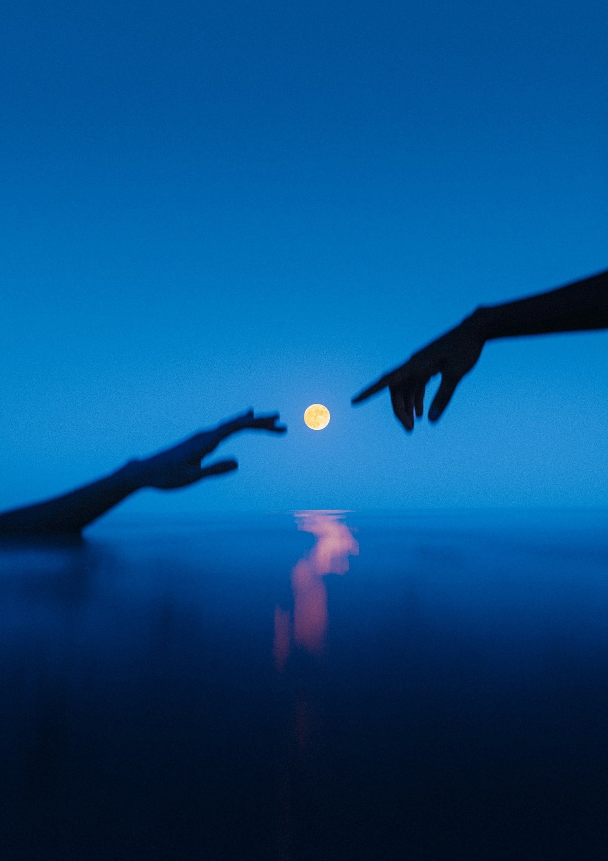 Two hands reaching out towards each other with a full moon in the background