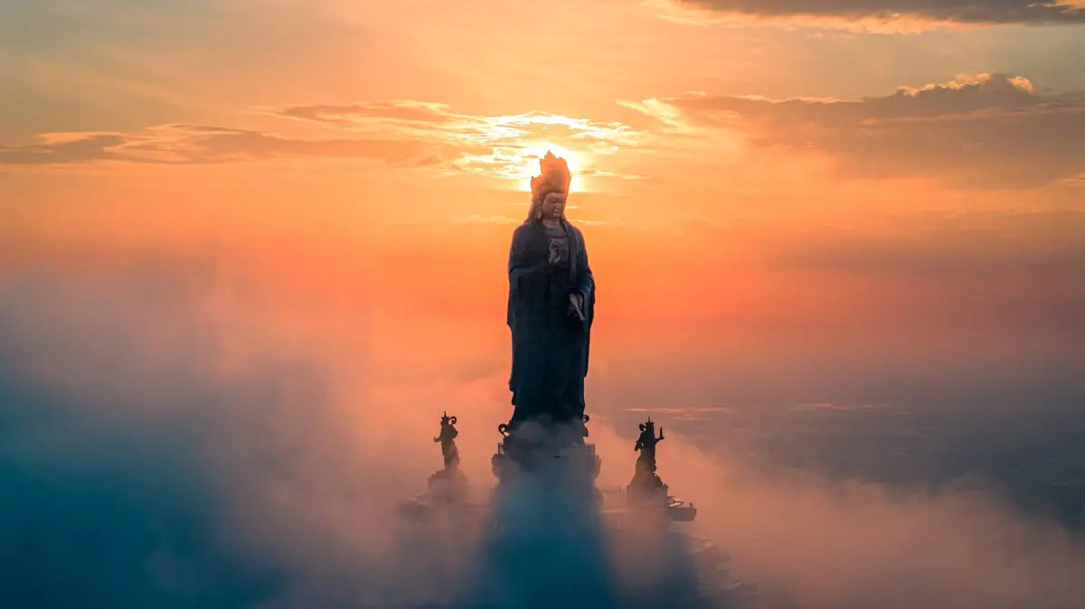Statue emerges from clouds at sunrise